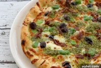 Fava Pesto Pizza with Fresh Favas, Black Olives and Taleggio
