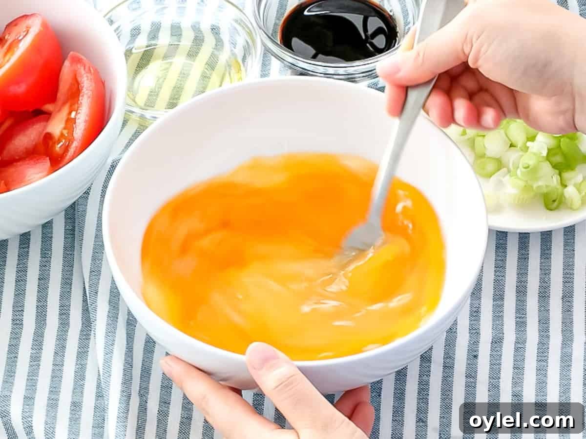 Eggs being mixed in a bowl with a fork.
