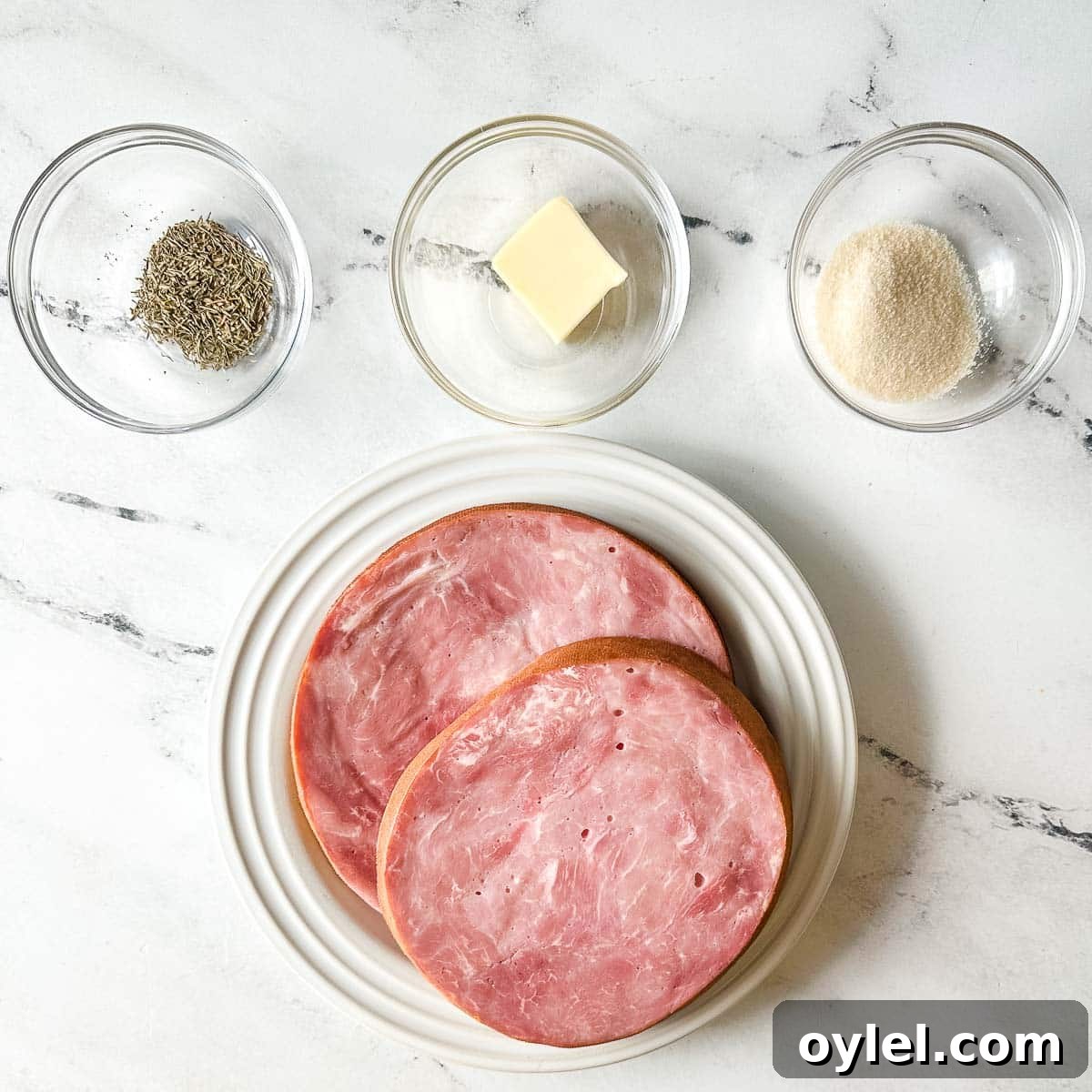 ingredients for air fryer ham steak on a white marble counter.