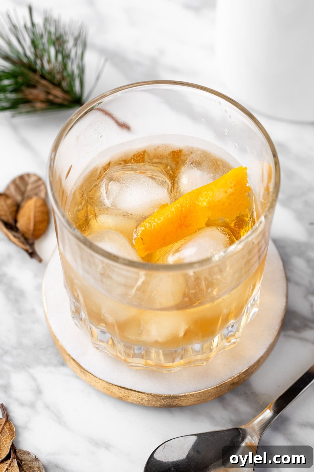 An Old Overholt Cocktail on a white and cocktail coaster.