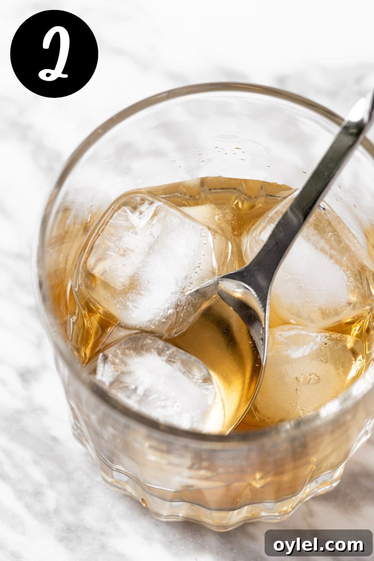 Stirring the ice in the cocktail to chill the drink.
