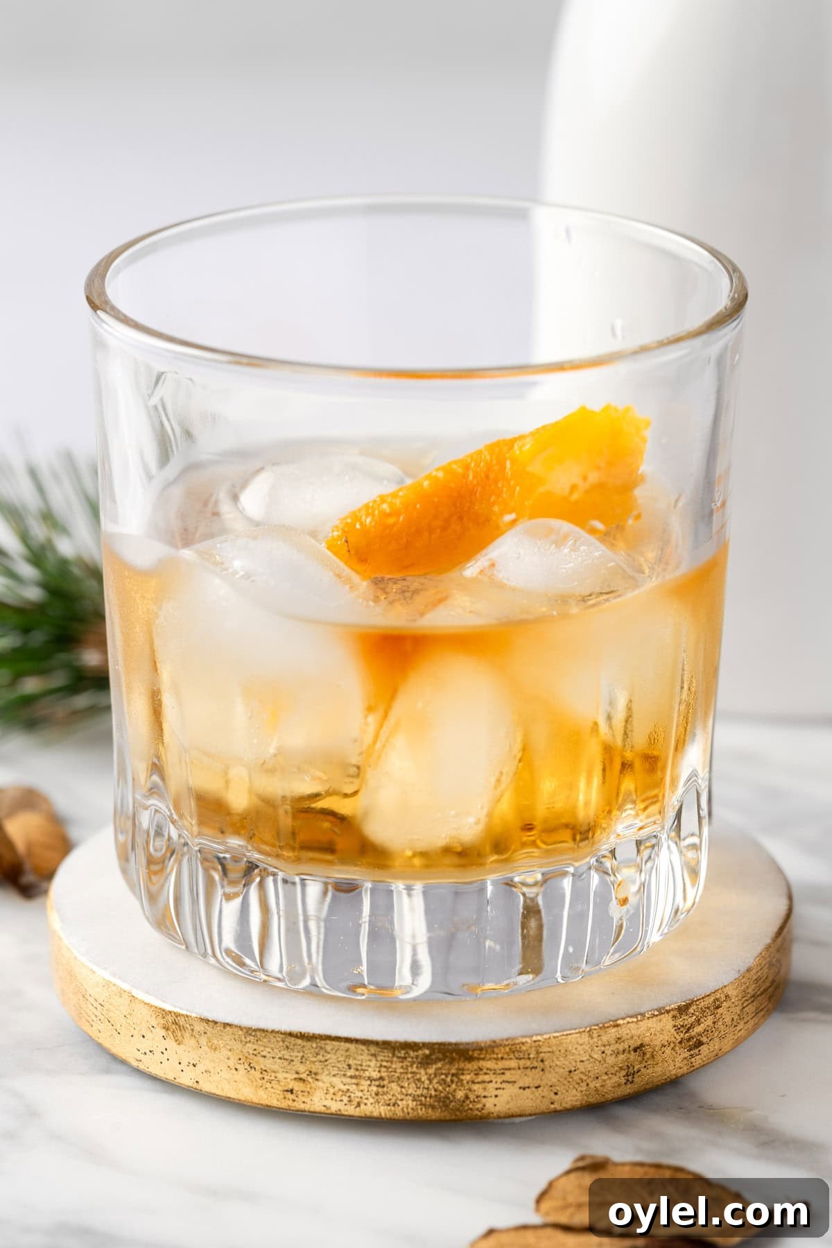 An Old Overholt whiskey cocktail garnished with an orange peel twist.