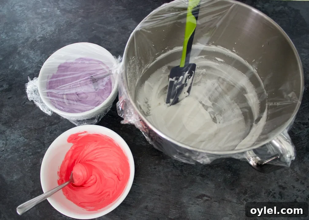 Different coloured royal icing in 3 bowls.