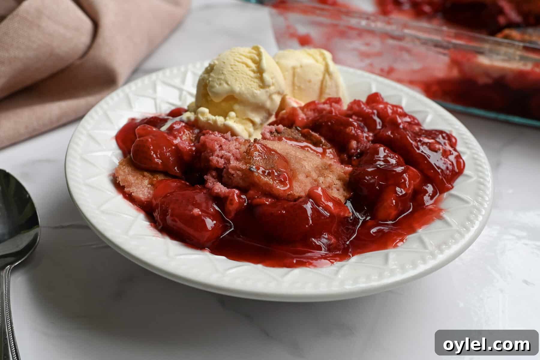 One-Bowl Strawberry Dump Cake Recipe 2 strawberry dump cake in a bowl with ice cream.