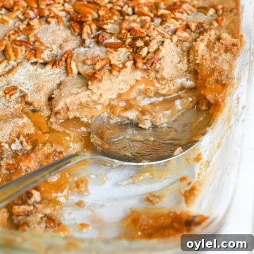 spoon in a dish of caramel apple dump cake.