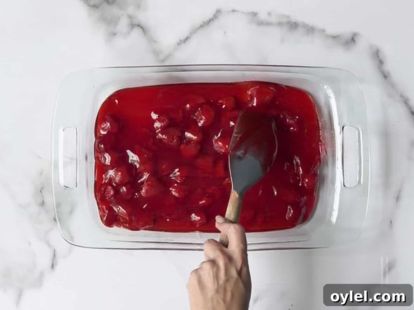 One-Bowl Strawberry Dump Cake Recipe 6 spreading strawberry pie filling in the bottom of a 9x13" dish.