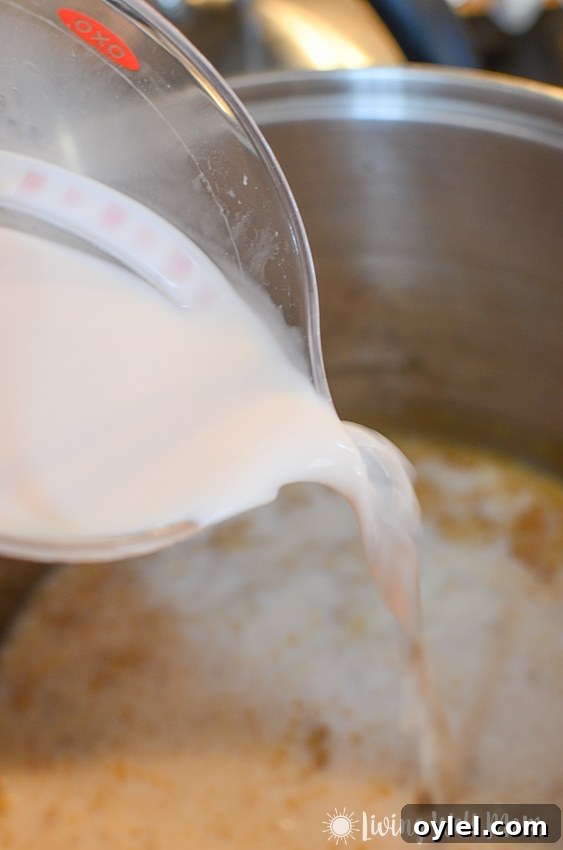 pouring milk into a pan for baked mac and cheese recipe