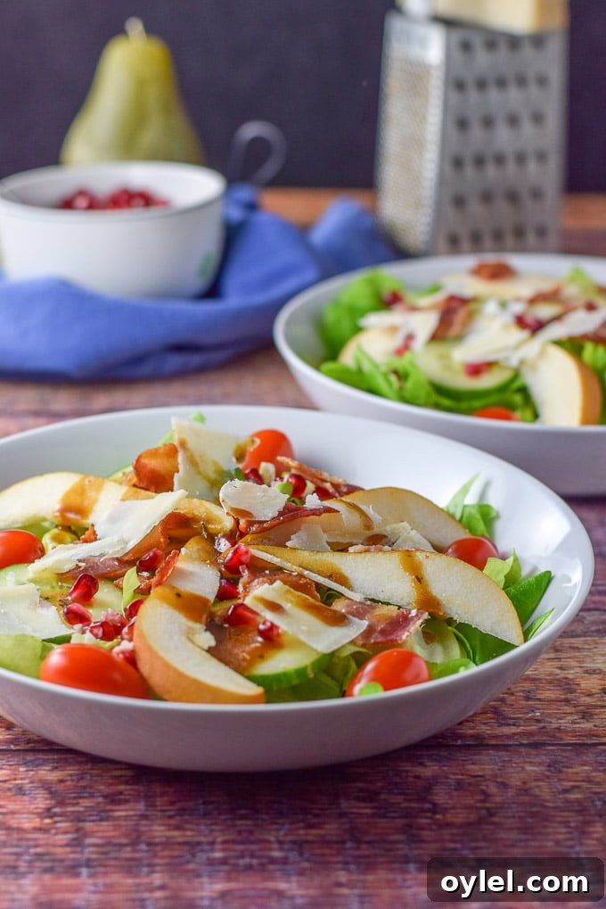 Balsamic dressing and shaved parmesan on the pomegranate salad with another salad and cheese in the background