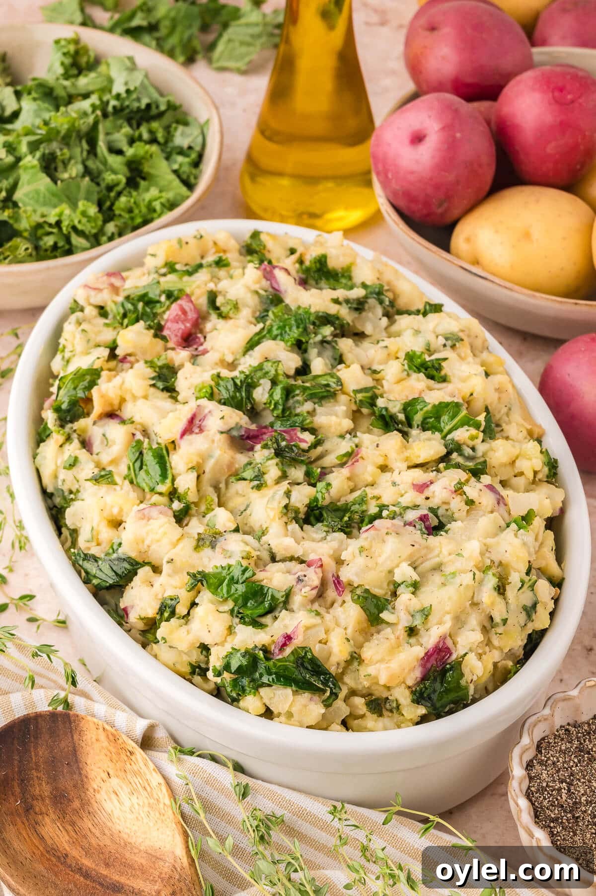 Olive oil mashed potatoes with kale and herbs on a table.