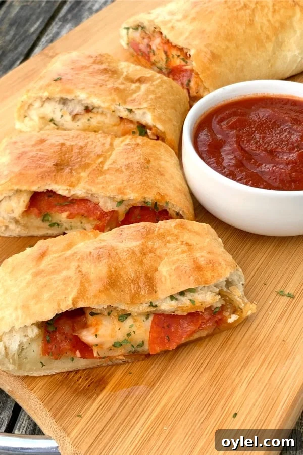 Slices of easy stromboli made from frozen bread dough with marinara sauce on a cutting board.