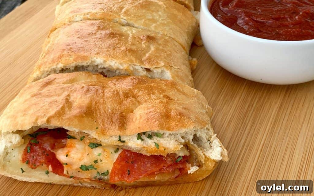 Slice of semi-homemade stromboli pizza with pepperoni and cheese by marinara sauce