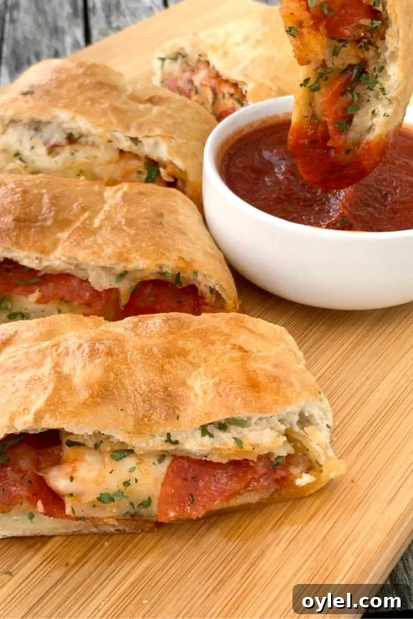Slice of farmhouse stromboli with Marinara Sauce dipping in a white dish.