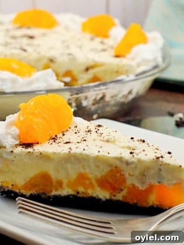Piece of Orange Creamsicle pie (dairy-free) on white plate with whole pie in background