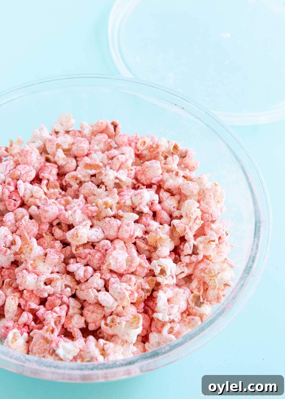Glass bowl with the popcorn and fruit powder all mixed up.
