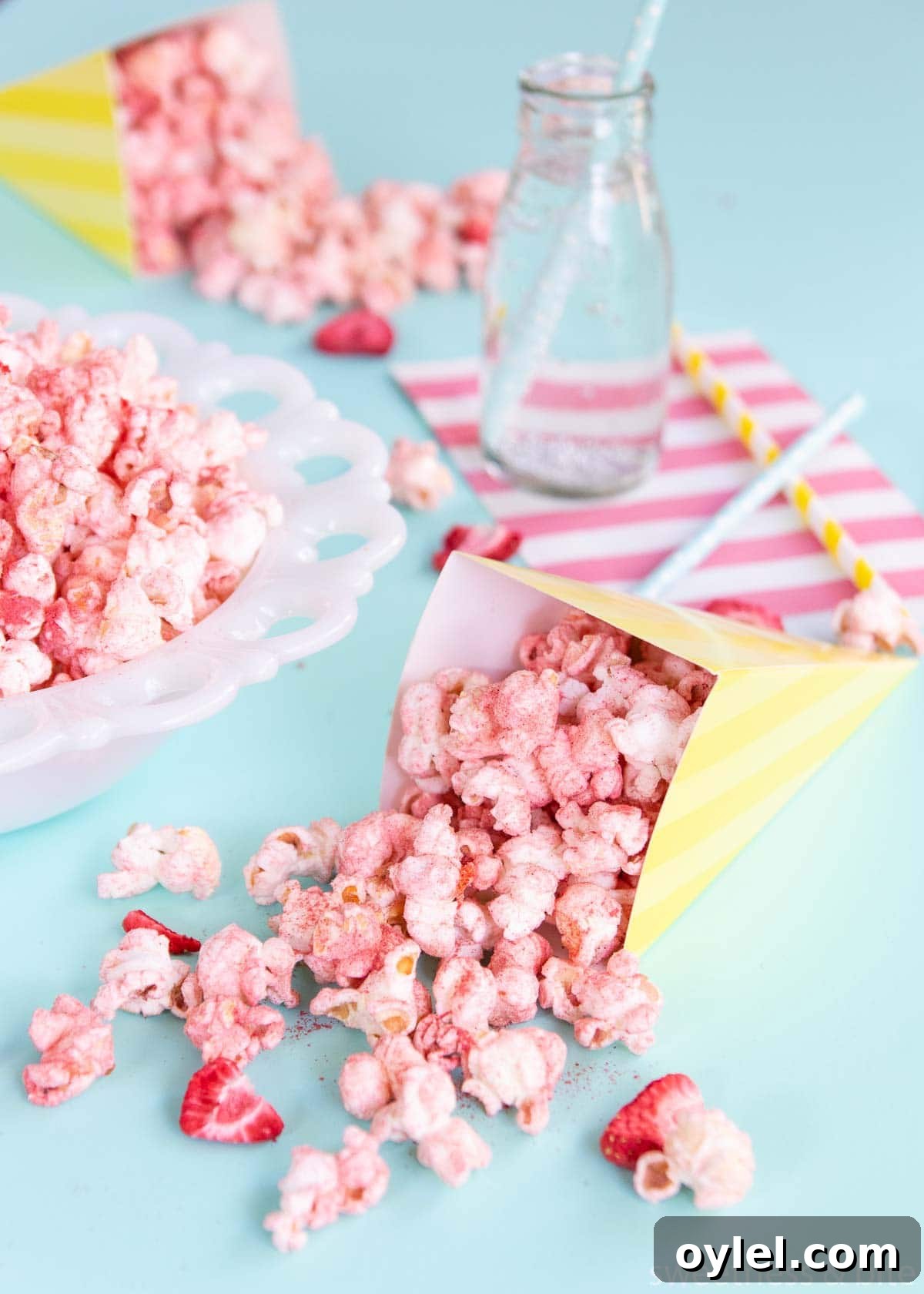 Flavoured popcorn in a yellow and white striped paper cone.