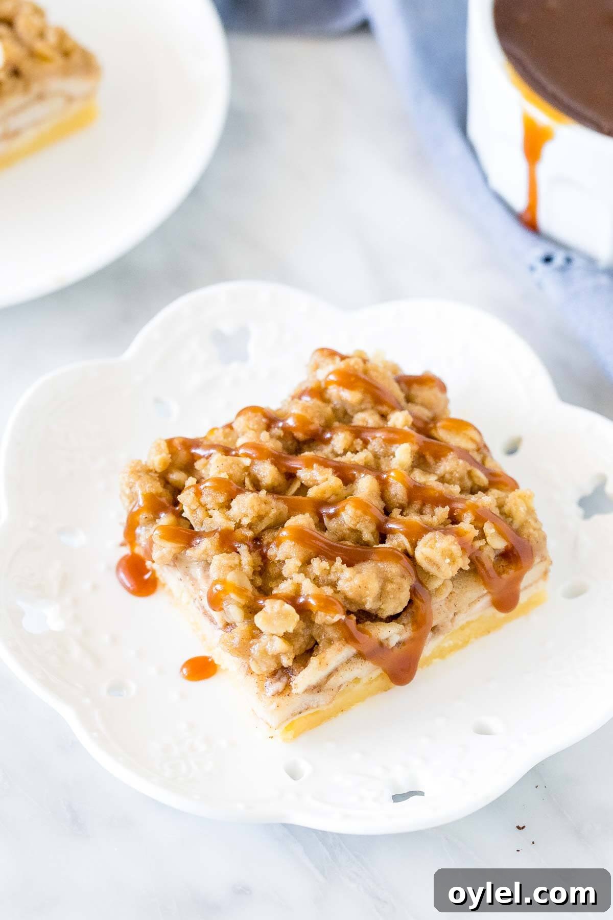 Slice of apple crumble on a plate with a drizzle of caramel on top.