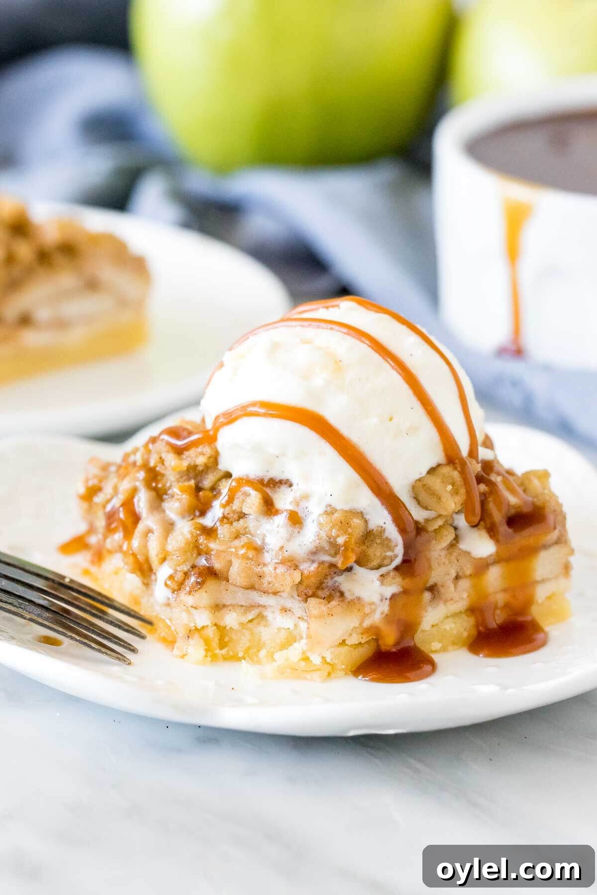 Apple crisp bar with shortbread crust and a scoop of ice cream on top.