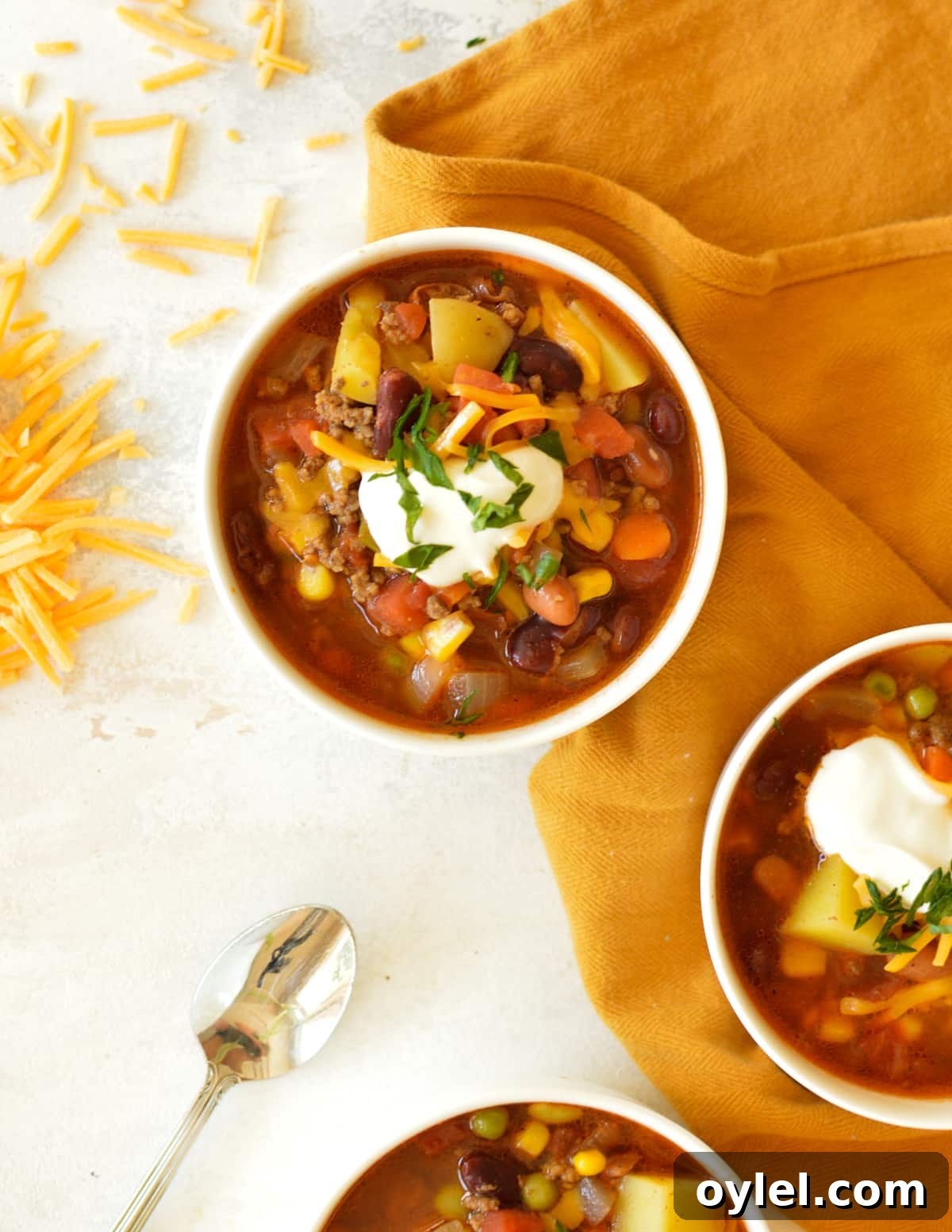 three bowls of cowboy soup with cheese and sour cream