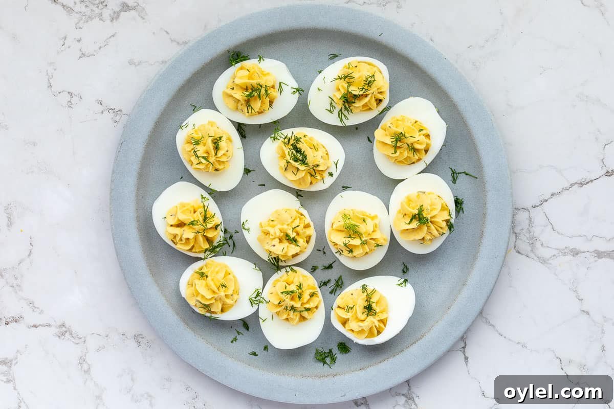 Deviled eggs on plate topped with fresh dill