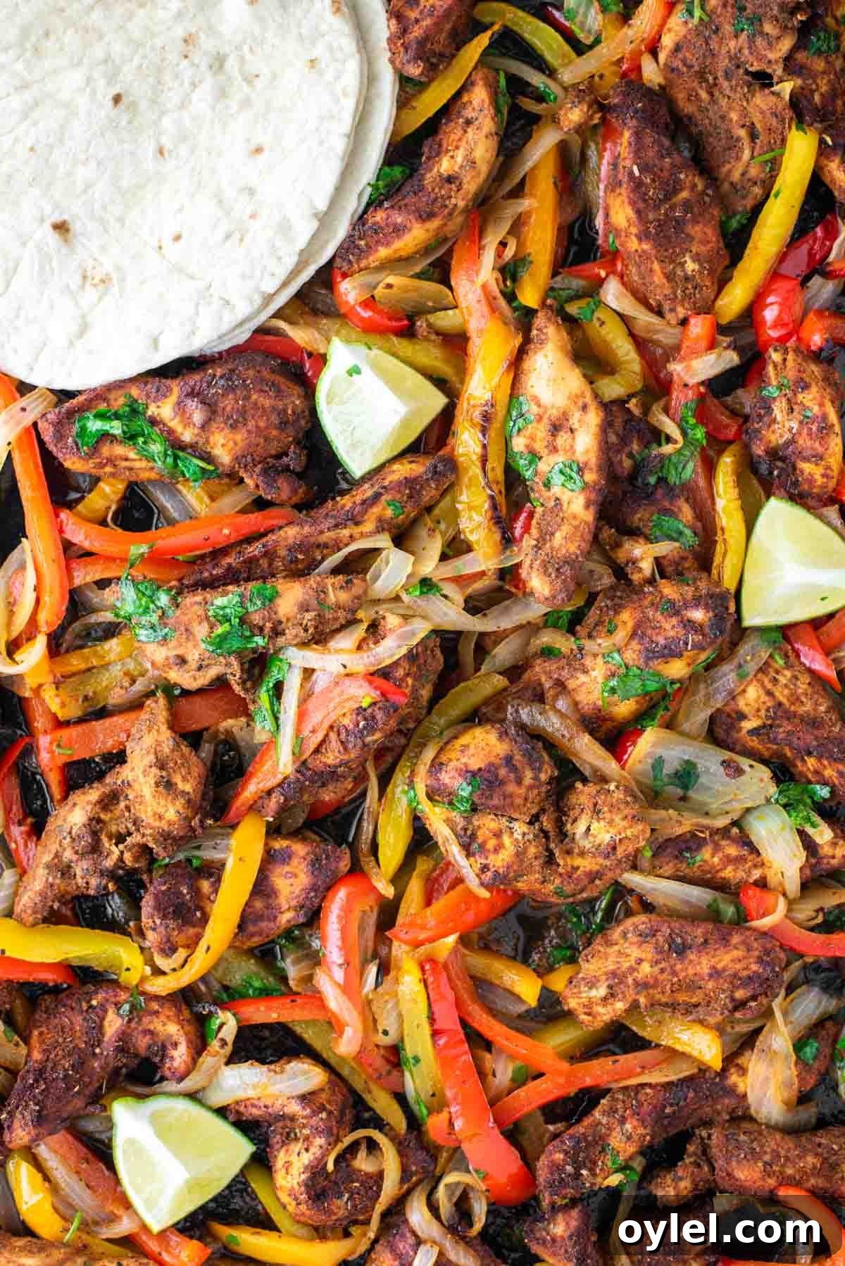 Sheet Pan Chicken Fajitas Recipe with Peppers and Onions 2 Chicken fajitas in sheet pan with tortillas.