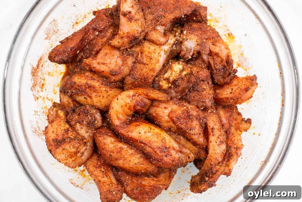 Sheet Pan Chicken Fajitas Recipe with Peppers and Onions 5 Chicken tossed in fajita seasoning in bowl.