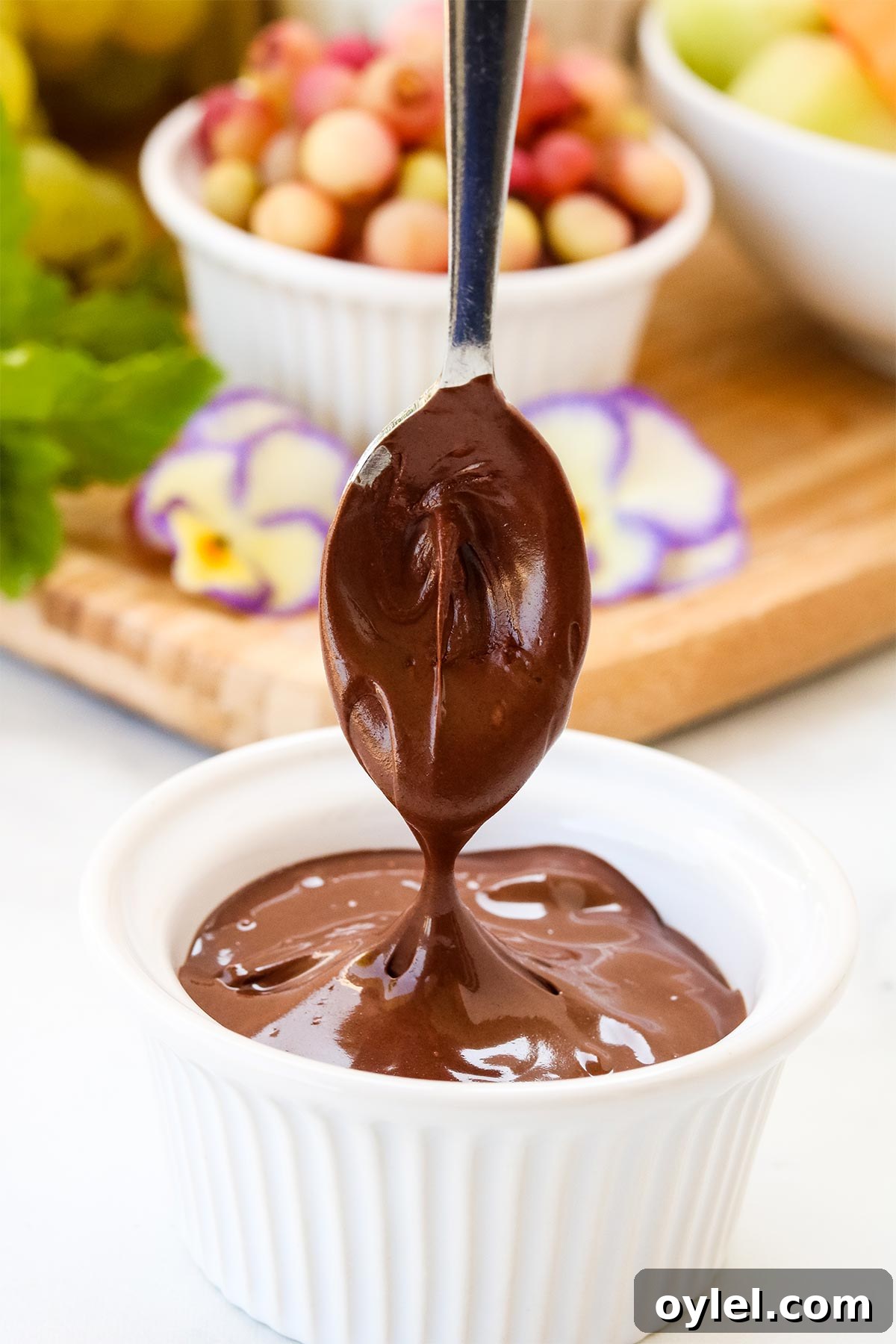 Spoon dipping into melted chocolate.