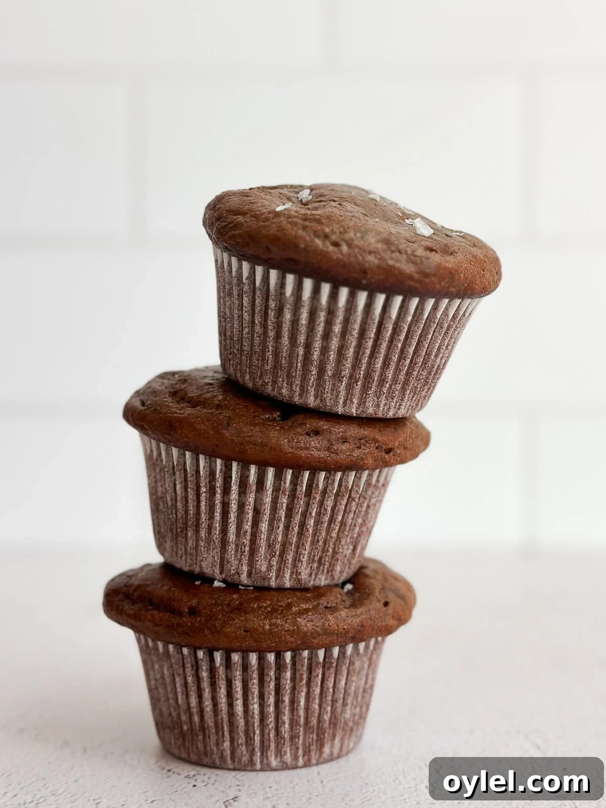 3 chocolate protein muffins stacked on top of each other.