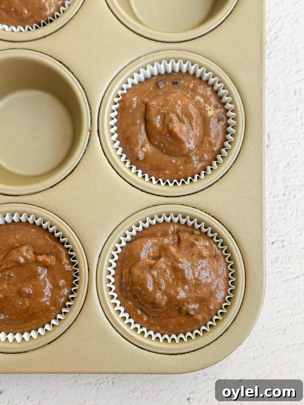 a close up of muffin batter in the cups before baking.