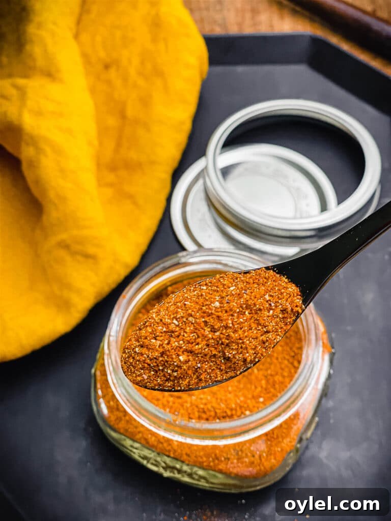Nashville Hot Seasoning Recipe: Homemade Spice Blend 2 a spoonful of Nashville hot seasoning with a jar in the background