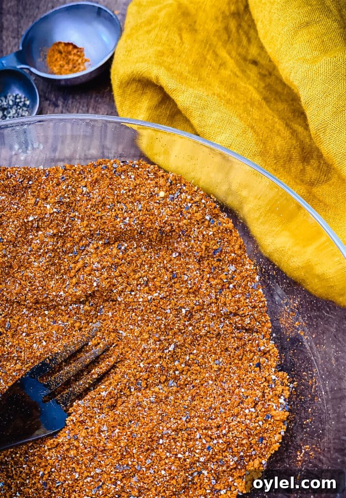 Nashville Hot Seasoning Recipe: Homemade Spice Blend 7 a fork in a bowl of Nashville hot seasoning