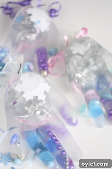 Melt Elsa's Frozen Hands: Preschool Sensory Science Experiment 3 latex gloves filled with water and pink, purple and blue beads, buttons and ribbons