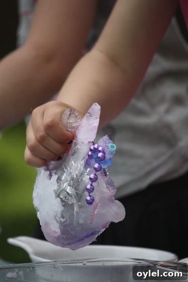 Melt Elsa's Frozen Hands: Preschool Sensory Science Experiment 8 preschooler melting ice hand with salt and water