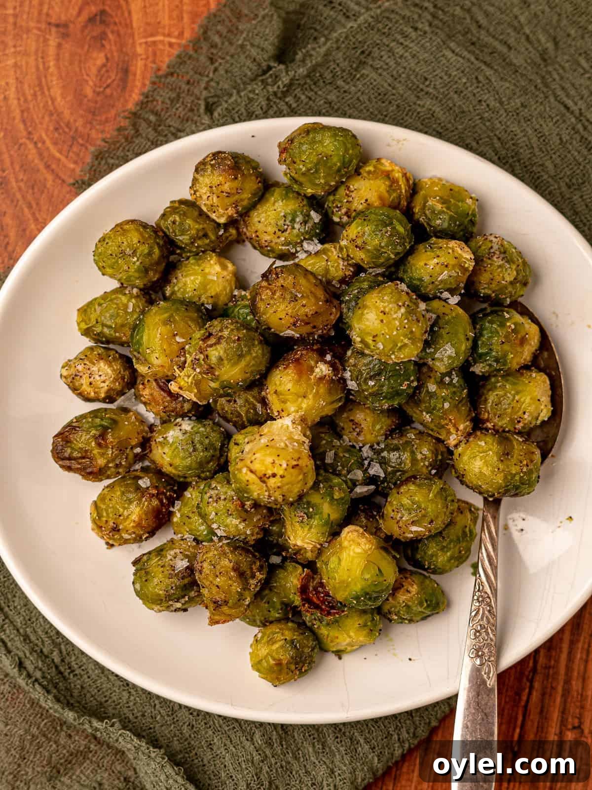 A plate of brussels sprouts with a serving spoon.