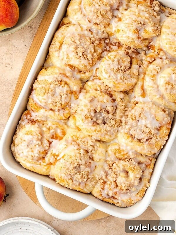 Peach cobbler cinnamon rolls in a baking dish.