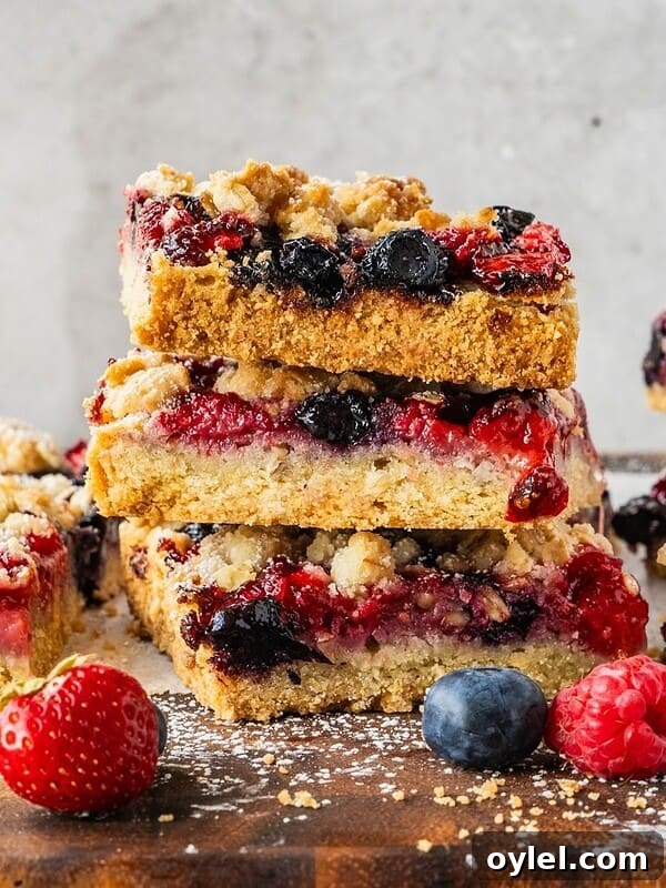 A stack of triple berry bars with oatmeal shortcrust.