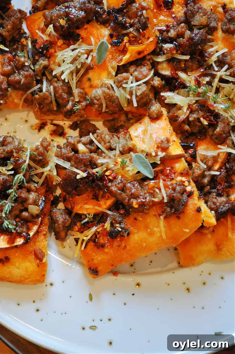 Sweet potato and vegan sausage flatbread on a baking sheet