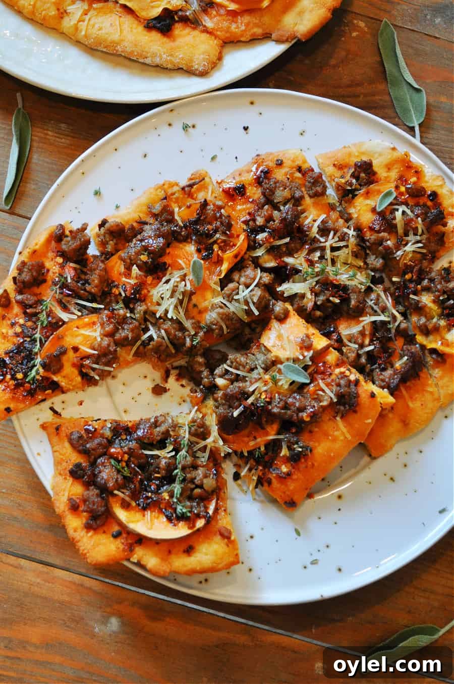 Two baked vegan flatbreads sliced and ready to serve