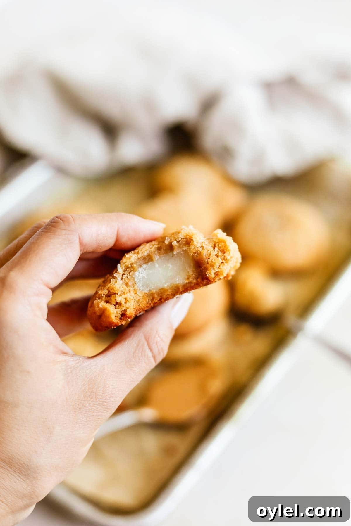 Chewy Miso Peanut Butter Mochi Cookies 7 Hand holding a mochi-stuffed peanut butter miso cookie with the center mochi exposed.
