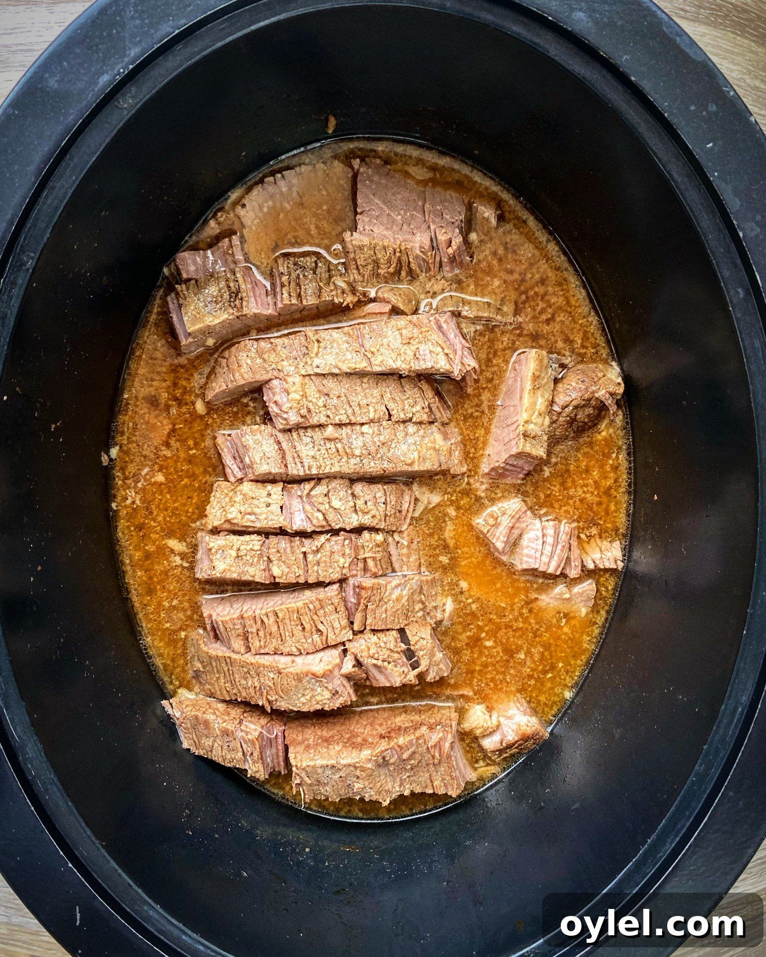 cooked, sliced against the grain brisket in the slow cooker