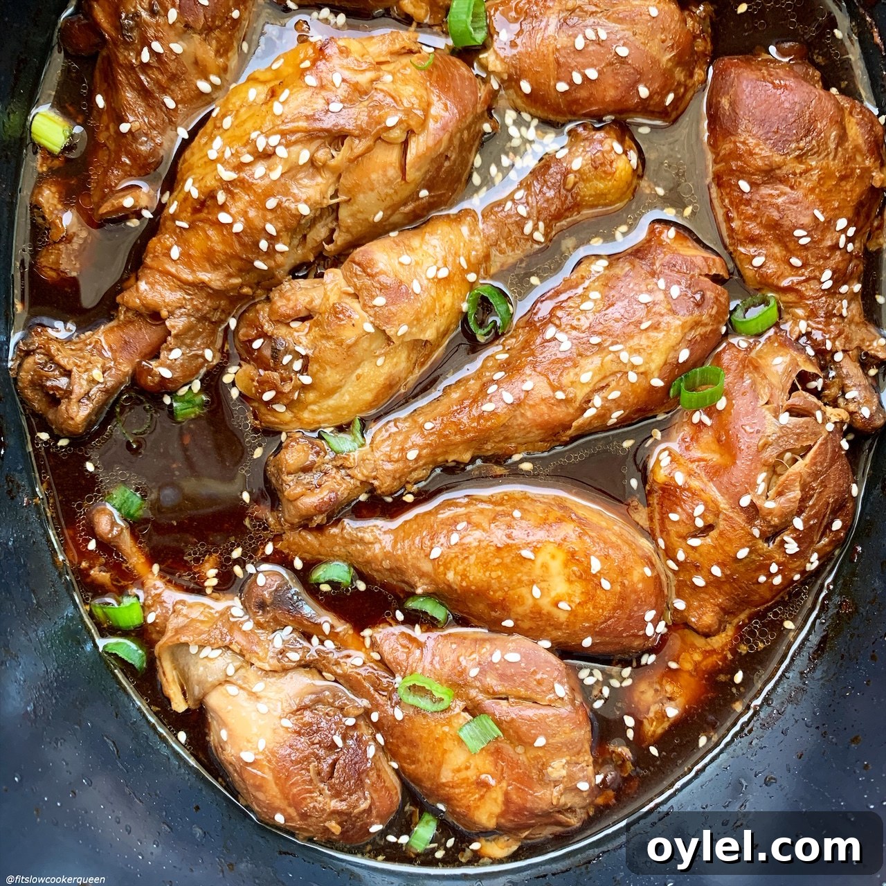 close up of after pic of cooked teriyaki chicken in the slow cooker with sesame seeds & green onions
