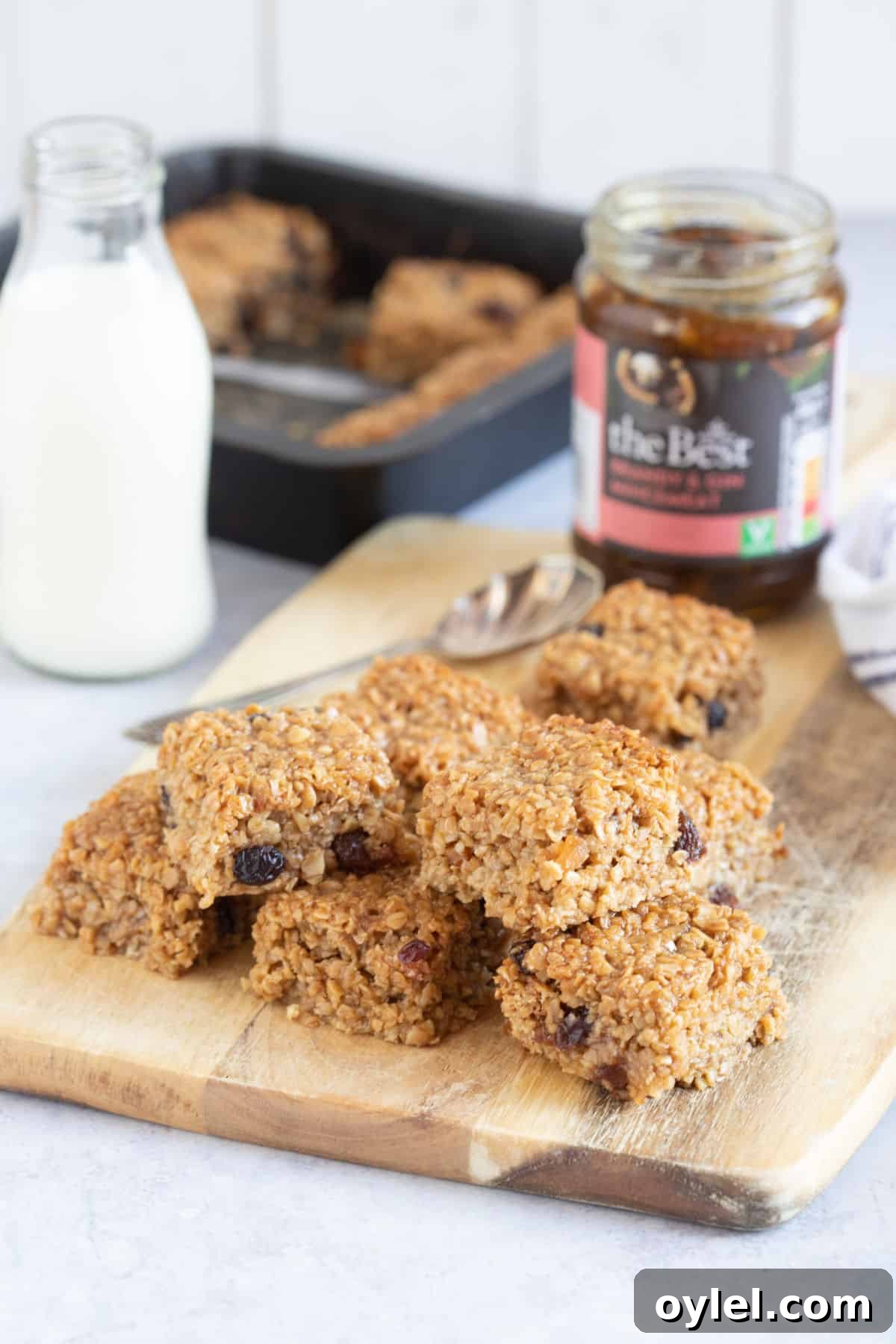 Mincemeat flapjacks on a wooden board with a jar of mincemeat behind.