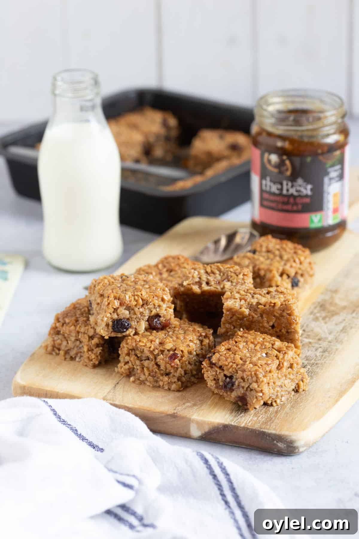 Mincemeat flapjacks on a wooden board with a glass of milk.