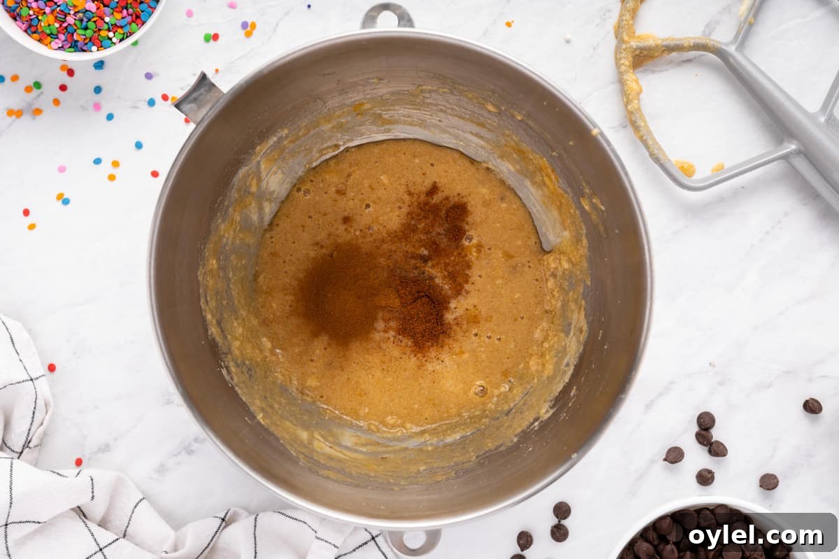 How to Make a Chocolate Chip Cookie Cake 19 wet ingredients for chocolate chip cookie cake in a metal bowl