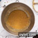 How to Make a Chocolate Chip Cookie Cake 8 wet ingredients for chocolate chip cookie cake in a metal bowl