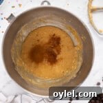 How to Make a Chocolate Chip Cookie Cake 9 wet ingredients for chocolate chip cookie cake in a metal bowl
