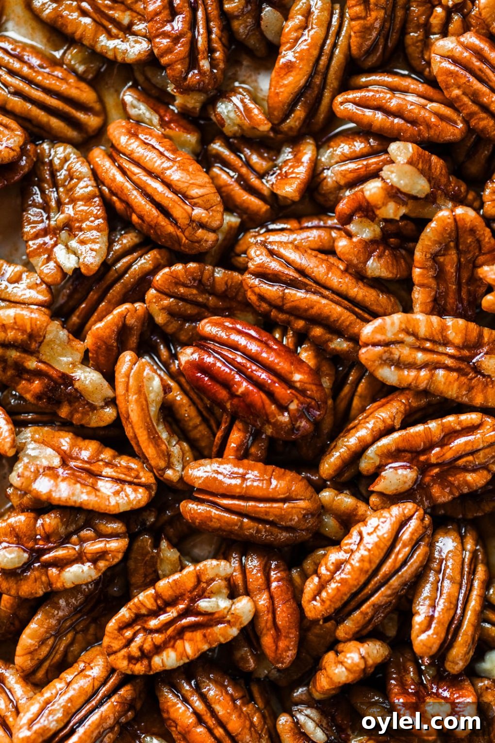 Maple Candied Pecans Recipe 4 Macro shot of raw pecans glistening with maple syrup and cinnamon mixture.