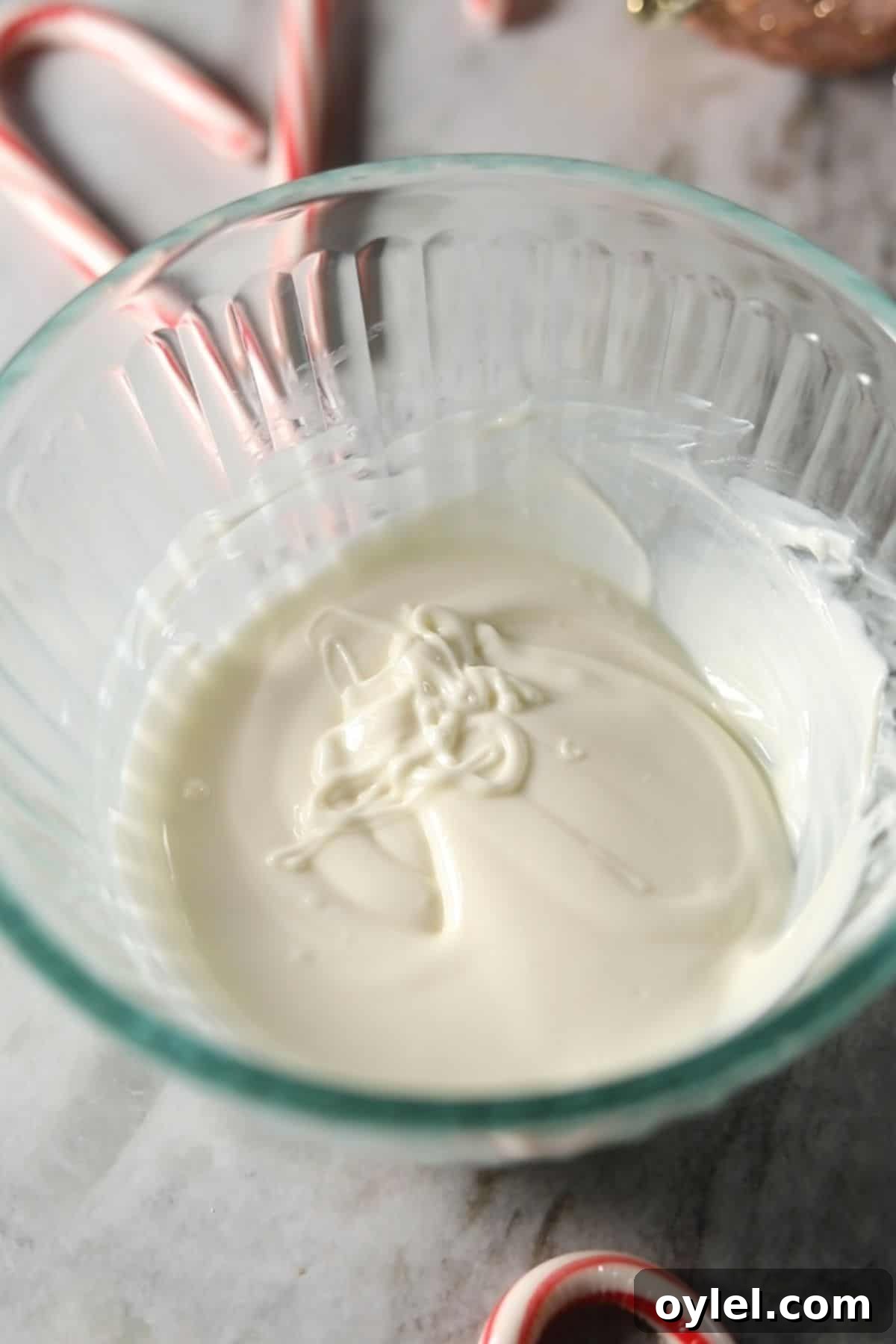 Melted white chocolate and shortening in a glass mixing bowl.