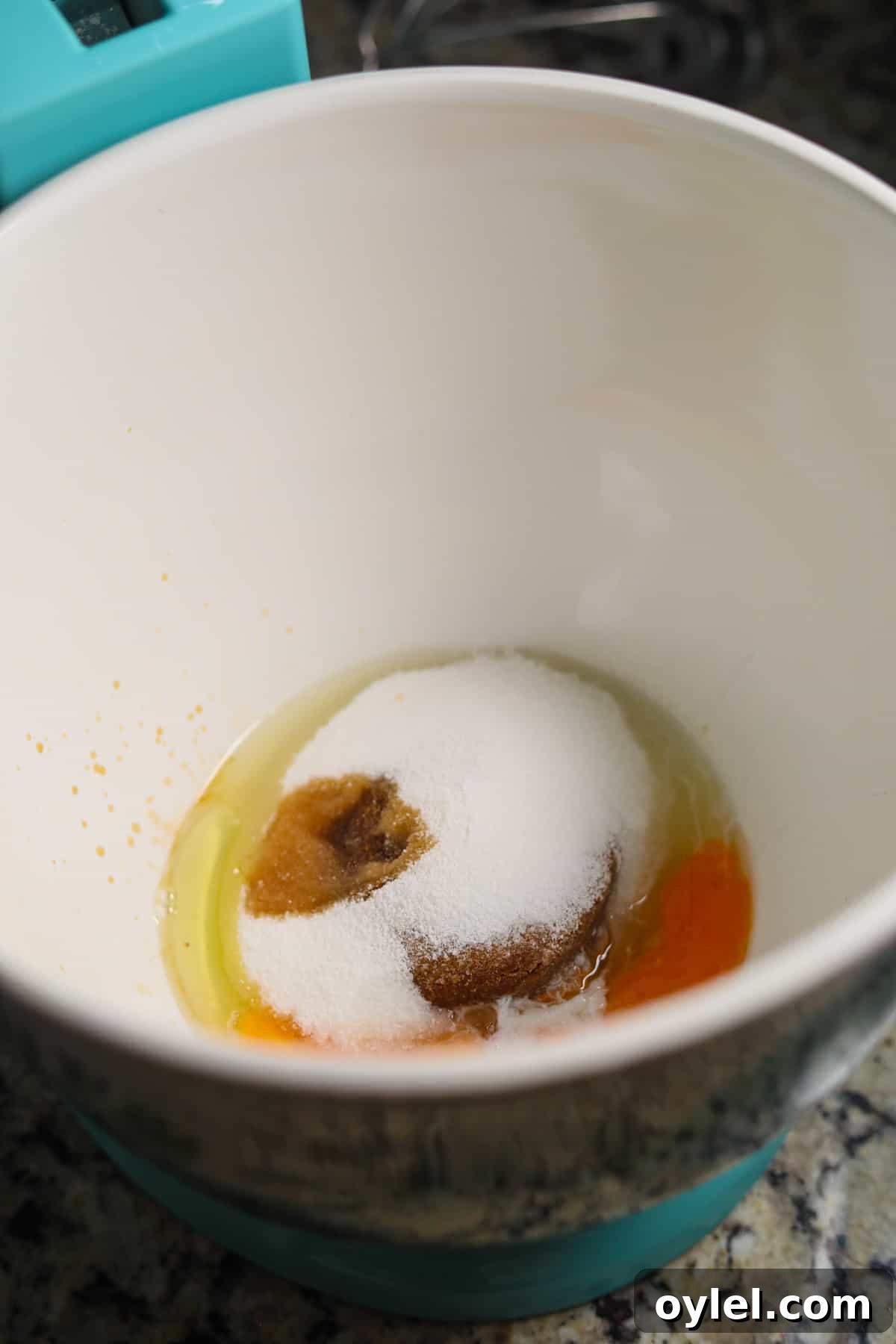 Eggs and sugars in a stand mixer bowl for making peppermint bark cookies.