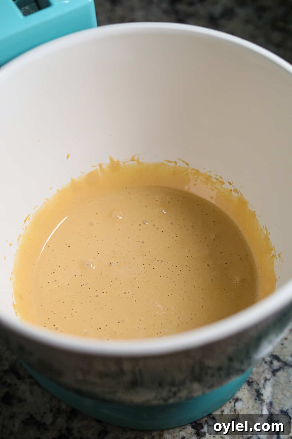 Beaten eggs and sugar in a stand mixer bowl for making peppermint bark cookies.