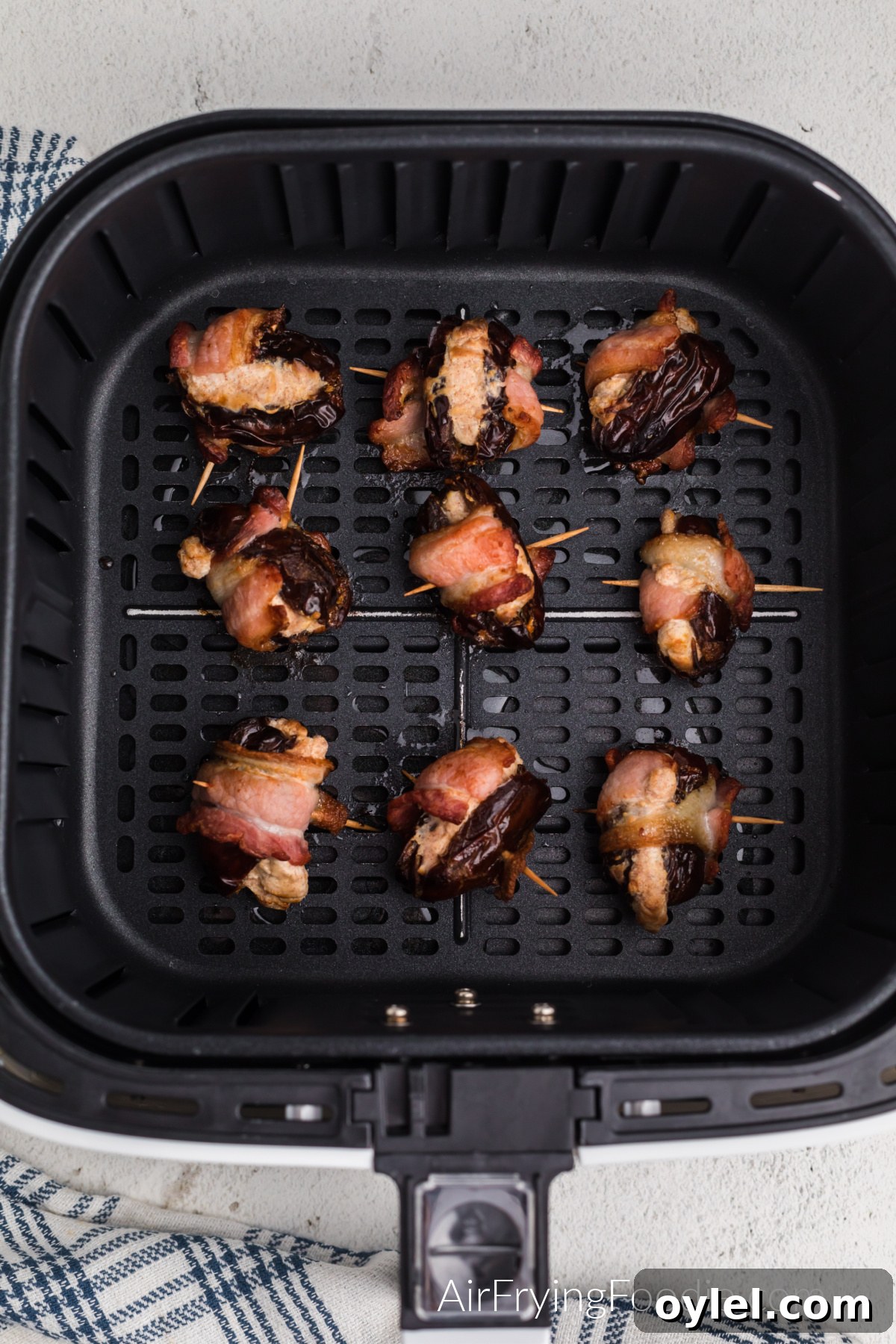 Air Fryer Bacon-Wrapped Dates Recipe 9 Air fried bacon wrapped dates in the basket of the air fryer.